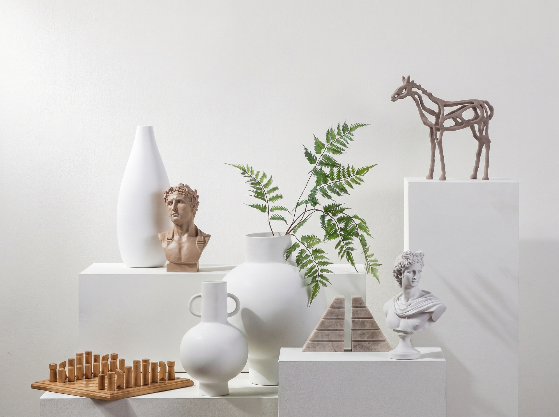 Ceramic vases and greenery styled on display pedestals