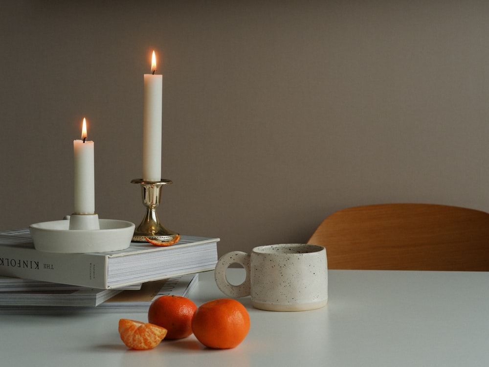 Brass taper candle holders with lit candles on a warm styled table